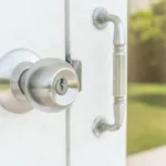 Manija de puerta de acero inoxidable con cerradura en una puerta blanca, mostrando un diseño moderno y elegante.